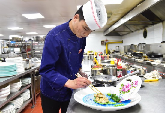 5月3日，刘旭峰在工作的酒店给主菜进行最后的装饰摆盘。