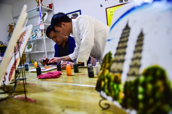 在阿峰果酱艺术工作室，刘旭峰（右）教学员画果酱画（4月28日摄）。